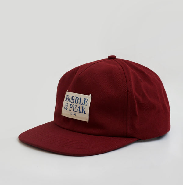 Limited edition claret hat by Bobble & Peak with minimalist two-tone design