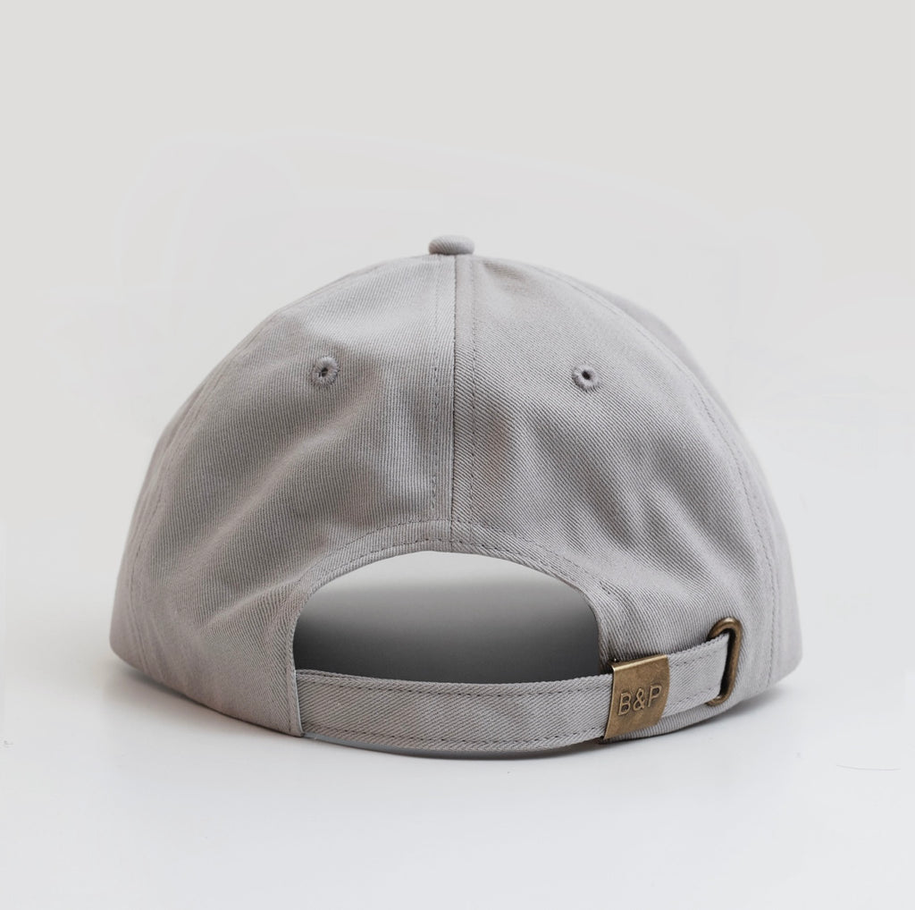 Grey cap with a visible brand logo on a light gray background