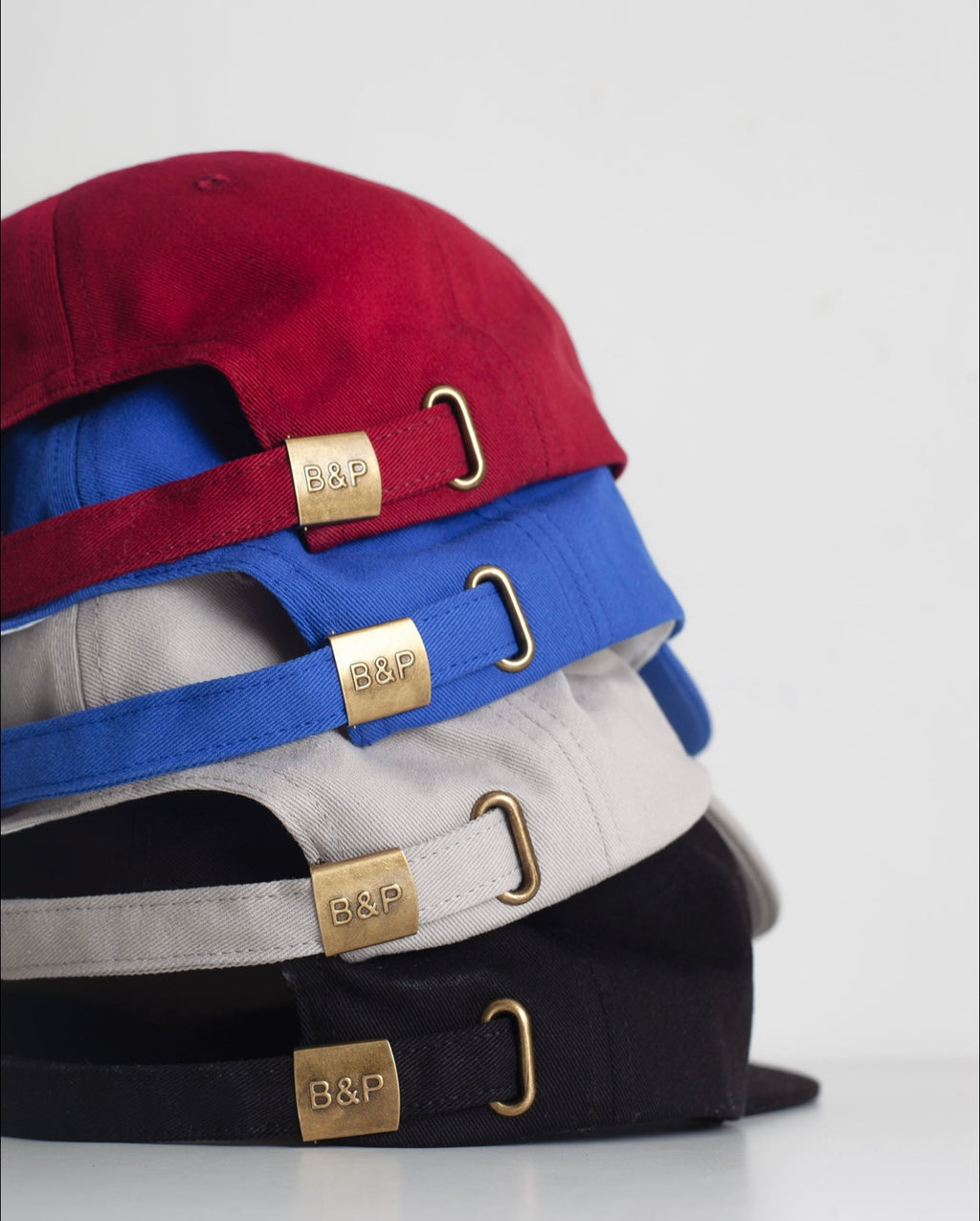 Stack of caps with visible brand logo on a light gray background