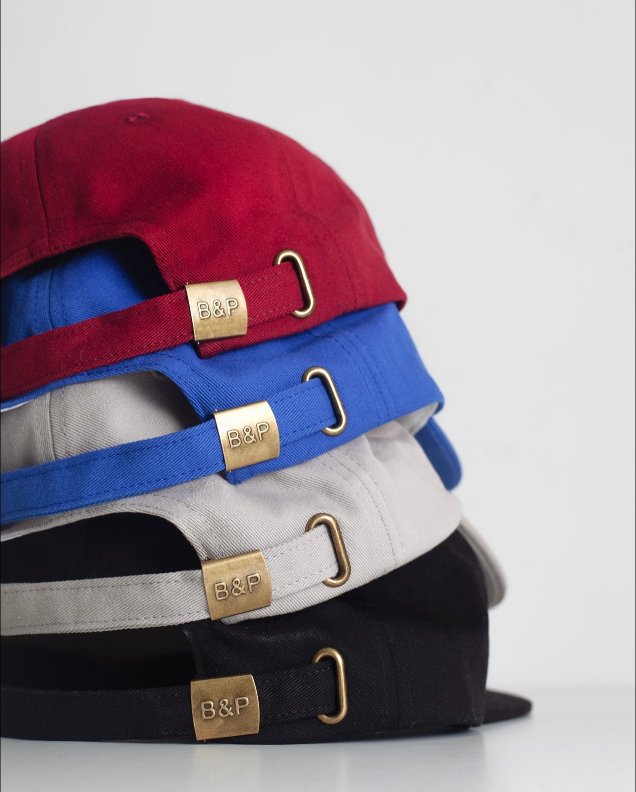 Stack of caps with visible brand logo on a light gray background