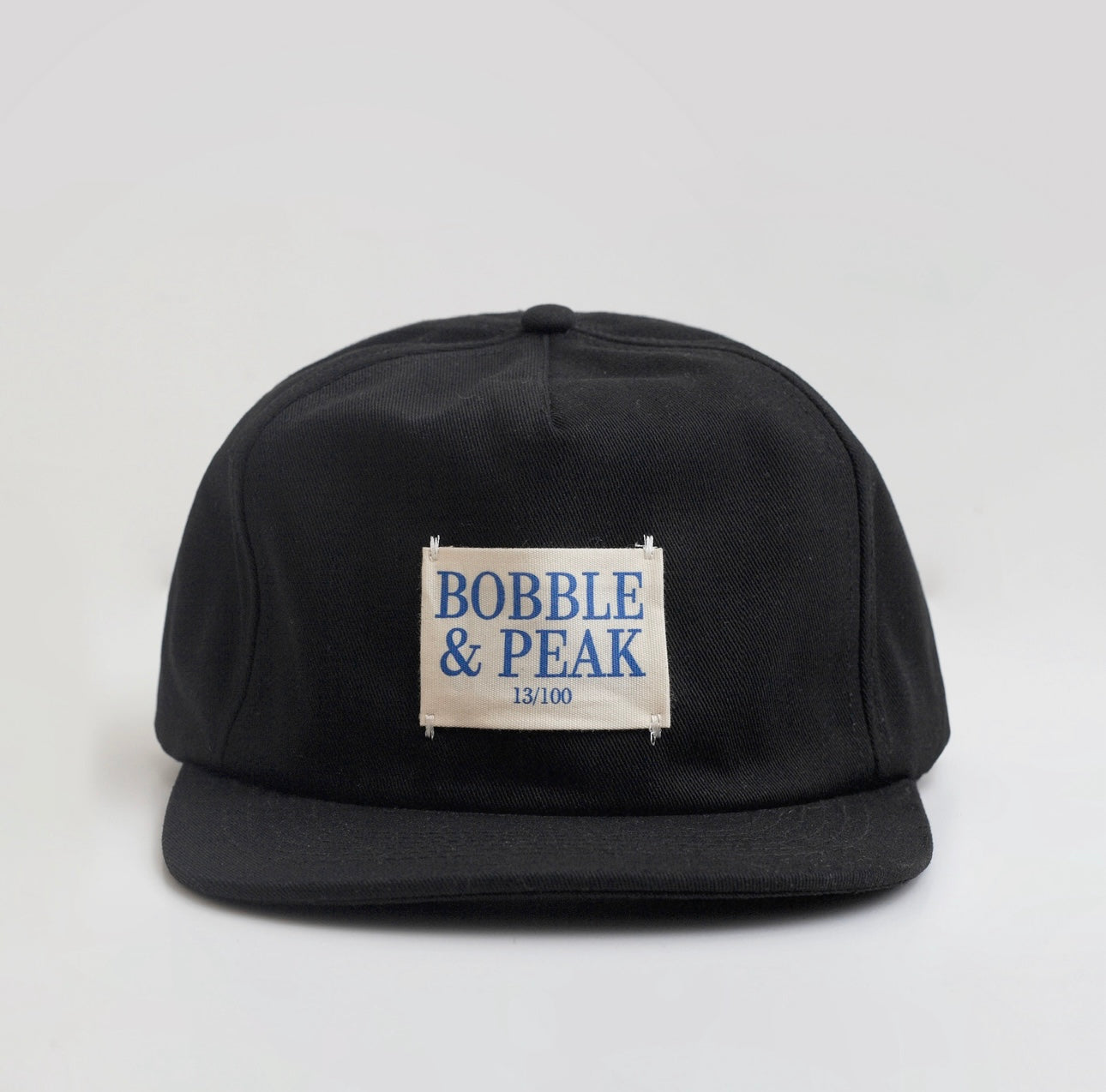 Black cap with 'Bobble & Peak' label on a light gray background